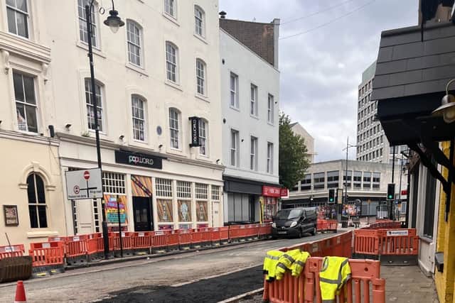 The area outside the bar has workmen and protective barriers around the pavement
