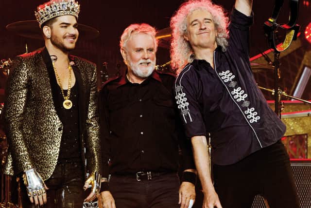 Adam Lambert, Roger Taylor and Brian May take in the applause of the crowd after the show