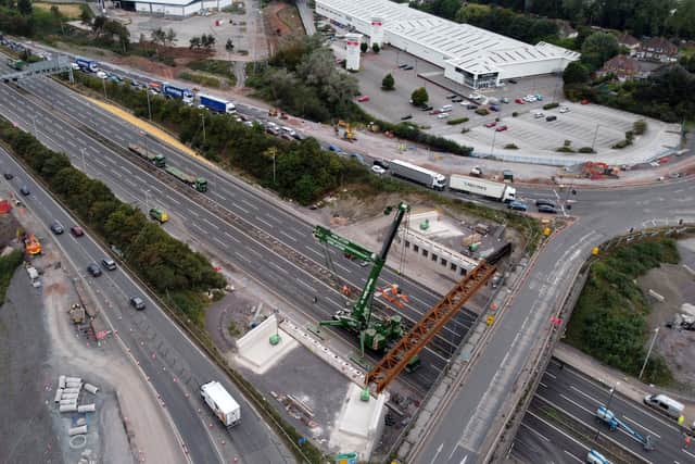 Bridge beams are being lowered into place by a large crane
