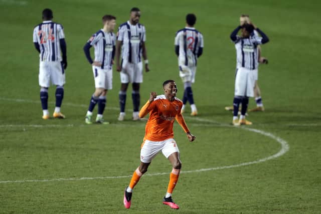 Blackpool's Marvin Ekpiteta celebrates as West Bromwich Albion players stand dejected following the Emirates FA Cup third round match at Bloomfield Road.