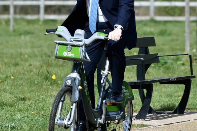 Prime Minister Boris Johnson rides a bike along the towpath in Stourbridge