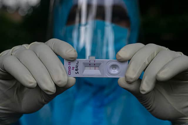 A health worker shows a Covid-19 positive test during a door-to-door test drive in Gauhati, India