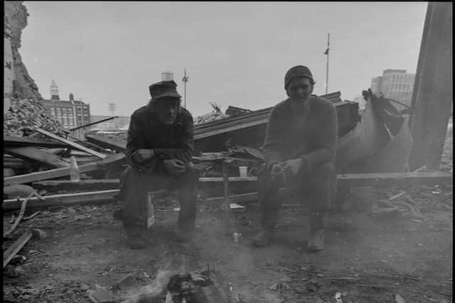 The demolition men sit round a fire during their break