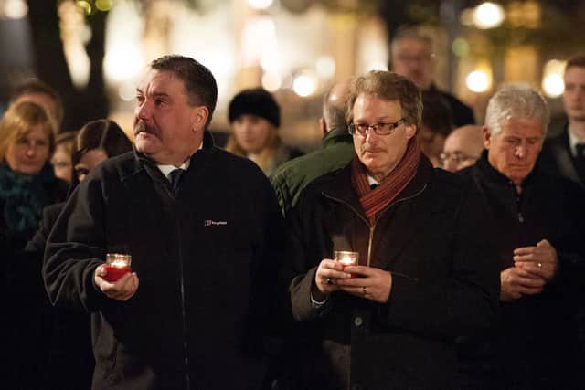 Candles are held by members of the public and the families of victims during a memorial service in 2014 at St Philip's Cathedral, Birmingham, for the 21 people who died in the Birmingham pub bombings