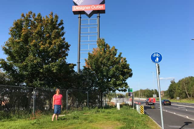 Parish Councillor Philippa Haden next to the sign