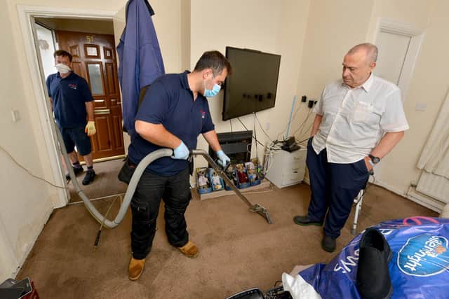 Barbast Bawa from Rainbow International Restoration helps Les Turner, 74, clean his house in Walker Street