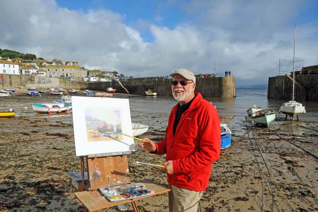 Artist and Black Countryman Nigel Hallard at work painting in  Mousehole harbour, Cornwall. Picture: Graham Gough.