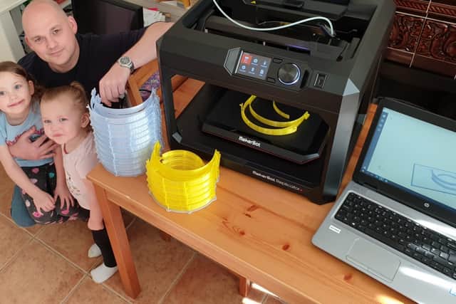 Dudley College tutor Dan Rudge with the college's 3D printer at his home. Pictured with his daughters Amelia, 4, and Georgia, 2