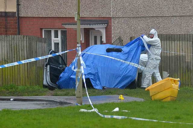 A blue sheet covering a car which appeared to have crashed on Wilson Road