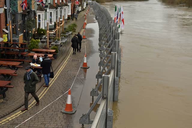 People walking past the temporary flood defences in Bewdley