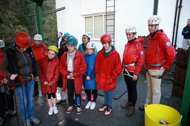 The Duke and Duchess of Cambridge listen to a briefing as they prepare to abseil down a wall during a visit to the Towers