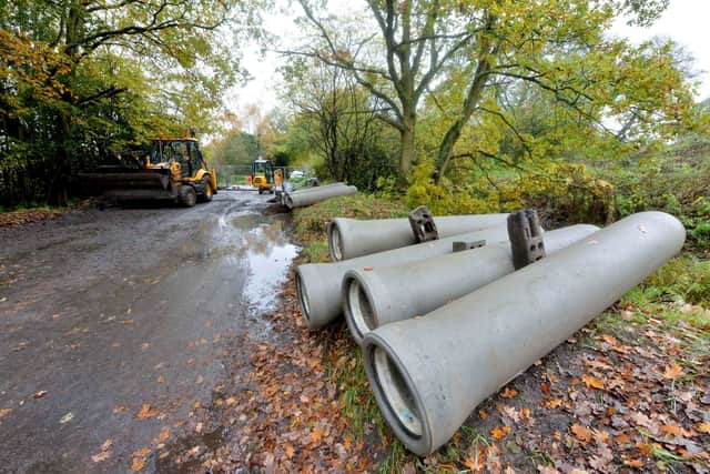 The work includes laying new concrete pipes under the road to carry water from a culvert