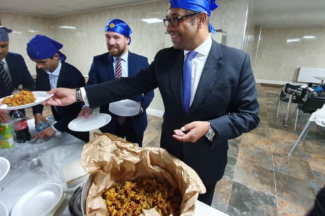 Conservative Party chairman James Cleverly tries his hand at serving food at the Guru Teg Bahadur Gurdwara in Wolverhampton.