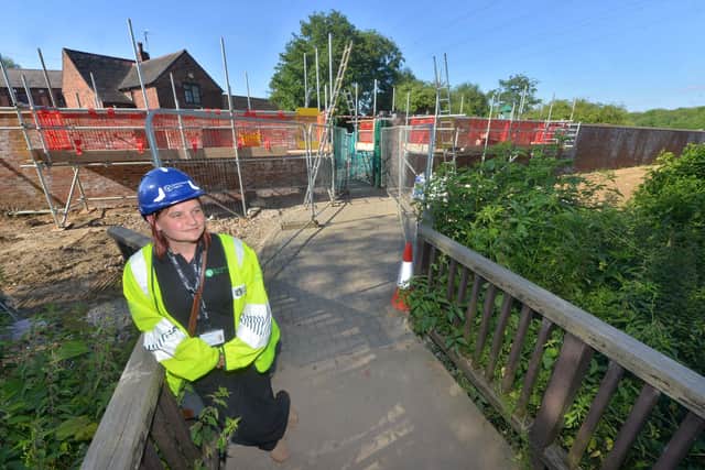 Imke Goalby stands in front of a new flood wall near Forge Mill Farm