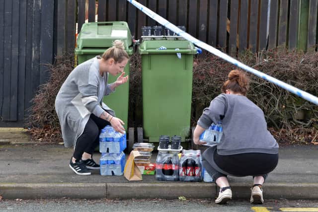People helping distribute food and drinks to emergency service workers