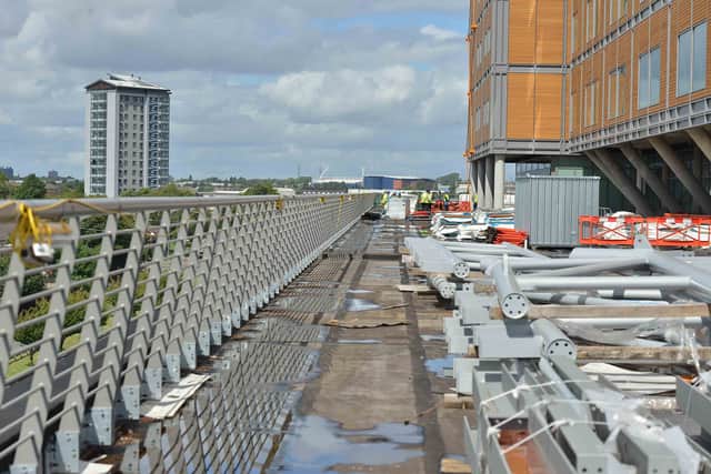 A walkway high on the site covered with building materials