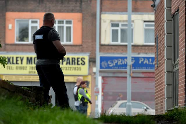 An officer stands guard at the side of the property