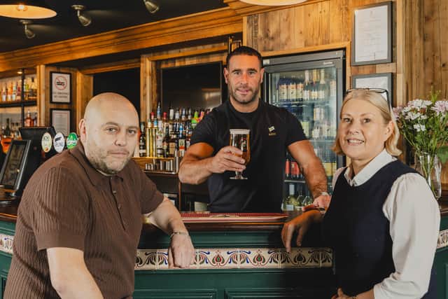 Community hero Craig Timmins pulls the first pint alongside pub partners Paul and Dawn Newlands