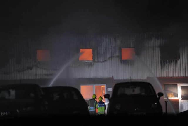 The store glows with the huge fire, which fire crews can be seen battling.