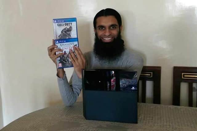Sajid Aslam posing with computer games Call of Duty and Assassin's Creed