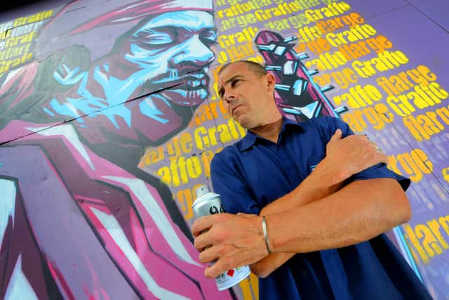 Graffitti artist Steve Edwards pictured next to his work depicting Jimi Hendrix.