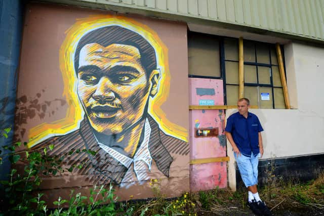 Steve Edwards beside his portrait of Goldie.