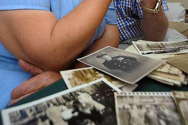 Joyce Onions with Peter Pritchard, with photos of Peter's family that Joyce rescued from a house years ago.