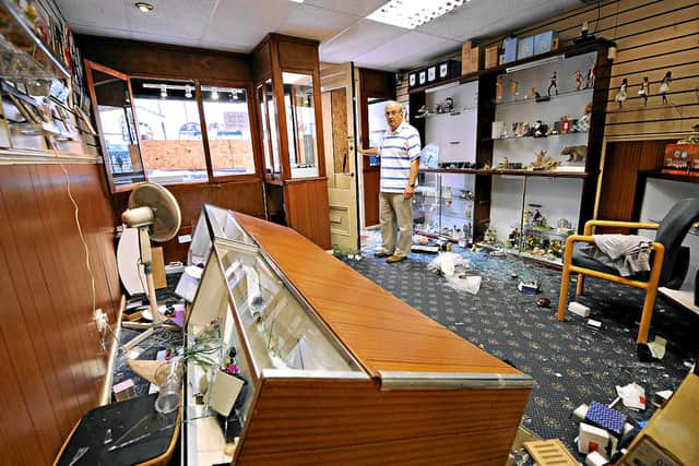 Eric Beckett surveys the damage to his shop after the riots in summer 2011