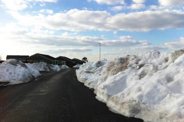 Cars are forced to squeeze past snow drifts on Greenwood Road, Aldridge