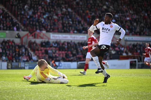 Walsall striker Daniel Kanu is beaten to the ball by Swindon goalkeeper Connor Ripley.