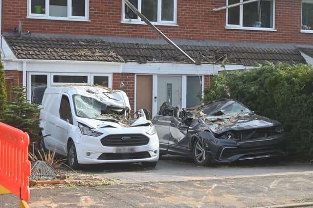Both cars were wrecked when a tree fell on them and the house