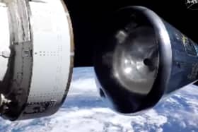 In this image from video provided by NASA, the Artemis II Orion capsule, right, separates from the service module above the Earth in preparation for splash down in the Pacific Ocean