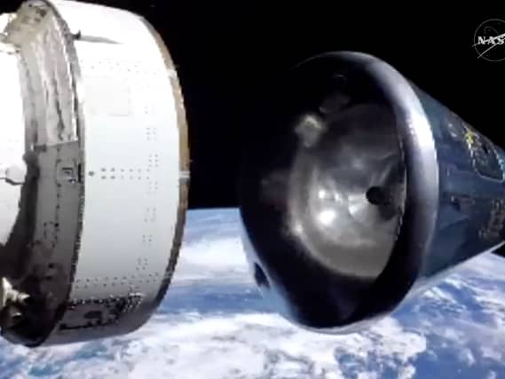 In this image from video provided by NASA, the Artemis II Orion capsule, right, separates from the service module above the Earth in preparation for splash down in the Pacific Ocean