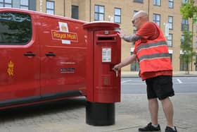 Postman at a Royal Mail post box