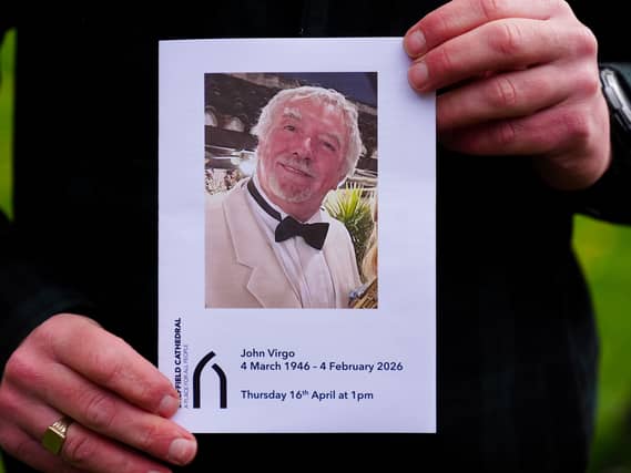 The Order of Service is held up ahead of the memorial service for John Virgo
