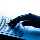 A woman’s hand pressing keys of a laptop keyboard