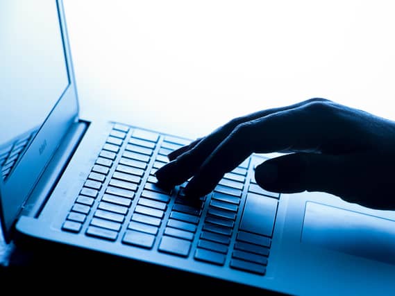A woman’s hand pressing keys of a laptop keyboard
