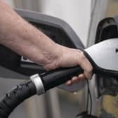 A person putting a car charger into their vehicle