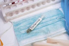 Test tube labelled Hantavirus on a mask, with gloves in a lab setting