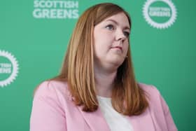 Gillian Mackay seated in front of Scottish Green signage