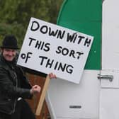 A man holding a 'down with this sort of thing' sign