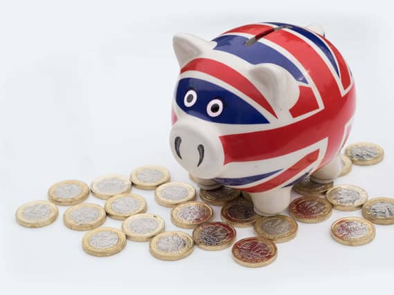 A Union flag design piggy bank surrounded by pound coins