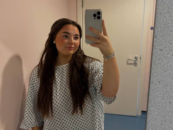 Ayley Crawford in a hospital gown taking a selfie
