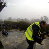 A screengrab from doorbell camera footage showing Catalin Stancu picking cat Nora up
