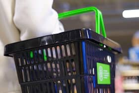A woman holds an empty shopping basket