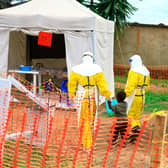 Health workers walk with a boy suspected of having the Ebola virus at an Ebola treatment centre in Beni, eastern Congo