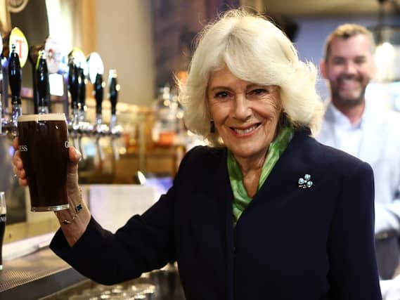 The Queen holds a pint of Guinness in a pub in the village of Hillsborough