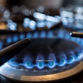 Close up of flaming gas rings lit on the hob of a domestic gas cooker in a UK kitchen setting.