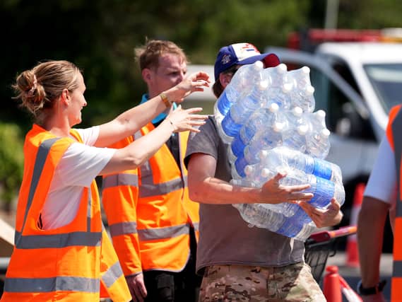 A man collects bottled water at a water collection point at a Sainsbury’s near Whitstable, Kent