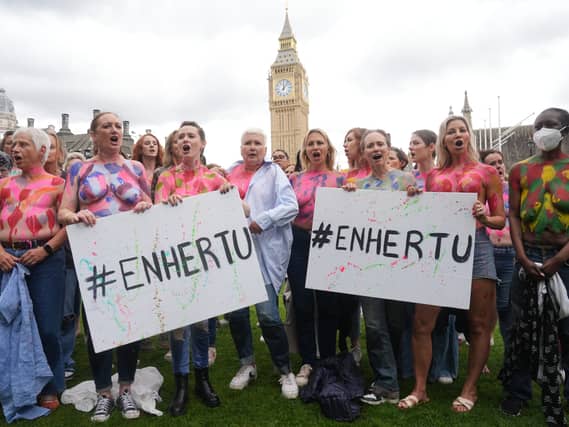 Campaigners in Westminster, central London, in July 2024 painted their breasts with messages calling for the breast cancer drug Enhertu to be made available on the NHS